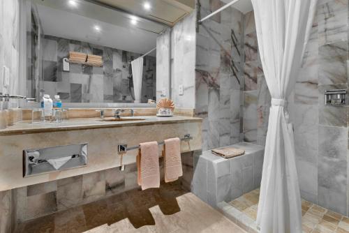 a bathroom with a sink and a shower at El Cid El Moro Beach in Mazatlán