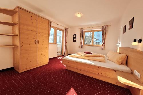 a bedroom with a bed and a large wooden cabinet at Ferienhaus Wöscher in Kaltenbach