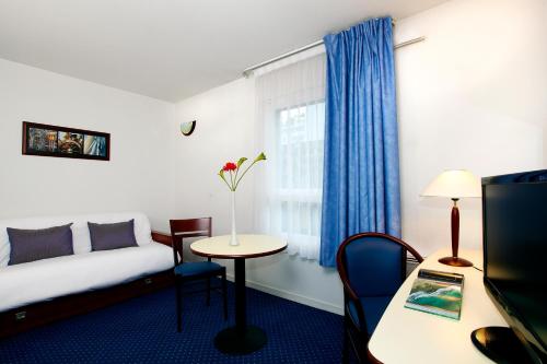 a hotel room with a bed and a table and a window at Appart'City Classic Clermont Ferrand Centre in Clermont-Ferrand