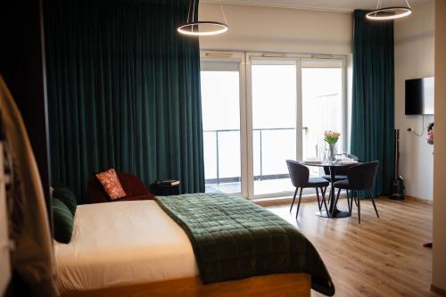 a bedroom with a bed and a table and a window at Apartament Centrum z tarasem prywatny parking in Płock