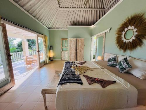a bedroom with a large bed with a mirror on the wall at Soma Bloom Resort in Jembrana