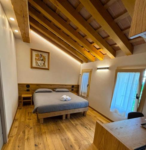 a bedroom with a bed in a room with wooden floors at Casa Tormena in Valdobbiadene