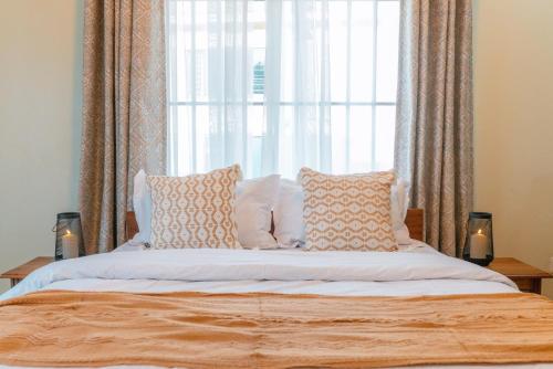 a bedroom with a bed with a large window at Starico Residence in Nkoanrua