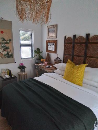 a bedroom with a large bed with yellow pillows at Acacia Home in Graaff-Reinet