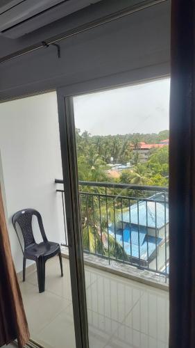 a balcony with a chair and a view of a pool at Krishna vykundam guruvayur in Guruvāyūr