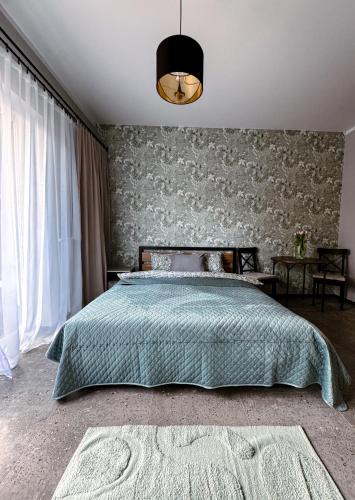 a bedroom with a bed with a green blanket at Studio 102 Garden in Krakow