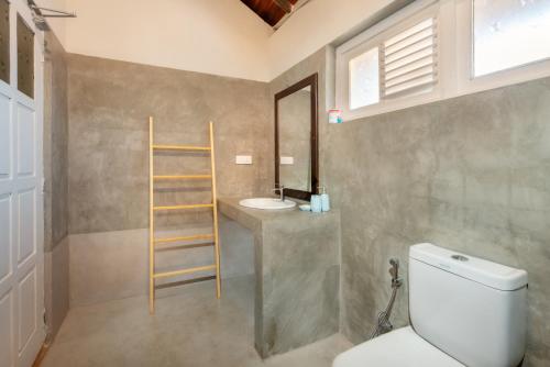 a bathroom with a white toilet and a sink at Shangrela Beach Resort by ARK in Ambalangoda