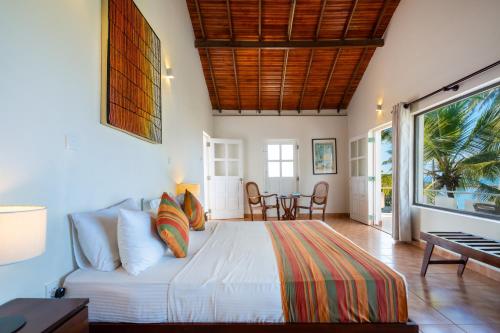 a bedroom with a bed and a table and chairs at Shangrela Beach Resort by ARK in Ambalangoda