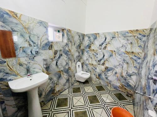 a bathroom with a sink and a toilet at Executives palace in Rāmgarh