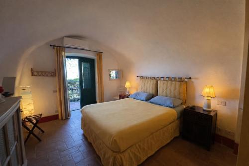 a bedroom with a large bed with blue pillows at Exclusive Villa - Relax - A-C - Stunning View in Porto Ercole