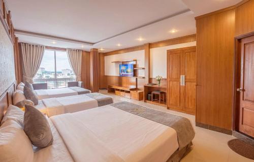 a hotel room with two beds and a television at Lien Do Star Hotel in Bảo Lộc