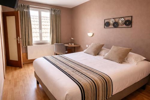 a bedroom with a large bed and a window at Logis Hotel Restaurant L'Escapade in Le Pêchereau