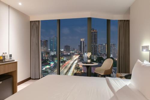 a hotel room with a view of a city at SZ Canalside Hotel in Bangkok