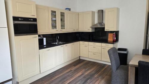 a kitchen with white cabinets and a wooden floor at Perfectly Located, Surprisingly Quiet in Gouda