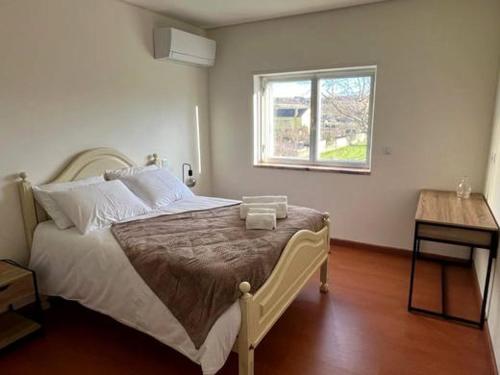 a bedroom with a bed with a window and a table at Casa Germano in Sabugal
