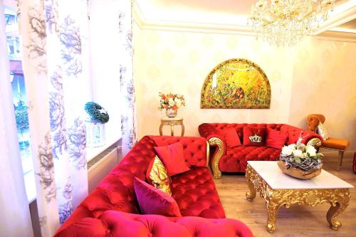 a living room with a red couch and a table at Boutiquehotel Villa Rosenhof in Badenweiler