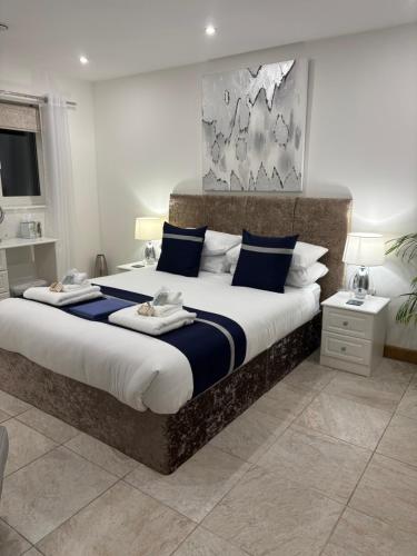 a bedroom with a large bed with blue and white pillows at Falconwood in Ifton Heath