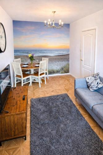 a living room with a table and a view of the beach at Seaside Cambois Apartment in Cambois