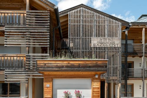 a house with a wooden facade with two garage doors at Mountain Exzelent Residence - Luxury Alpine Apartments in Anterselva di Mezzo