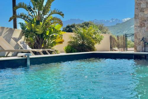 a swimming pool in a house with blue water at Villa casa Luna piscine chauffée vue mer proche centre et plage de Calvi in Calvi