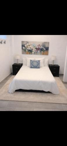 a bedroom with a white bed with a blue pillow at Beachfront Studio in Castillo de la Duquesa in Castillo de Sabinillas