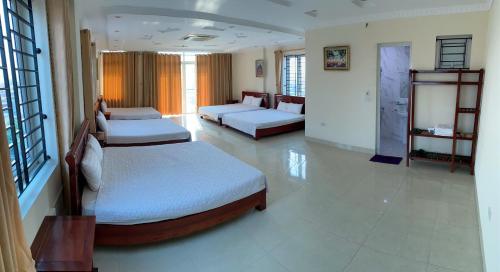 a large room with two beds and a couch at Khách sạn Tâm An in Ða Gia