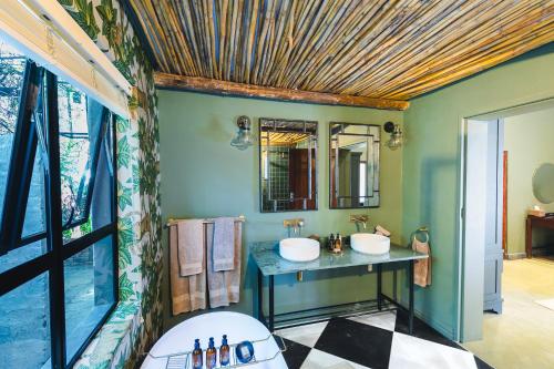 a bathroom with two sinks and a mirror at Last Word Madikwe in Madikwe Game Reserve