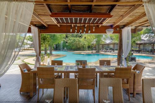 a dining room with a table and chairs and a pool at Almont Inland Resort in Butuan