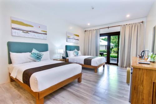a hotel room with two beds and a balcony at Almont Inland Resort in Butuan