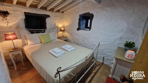 a bedroom with a bed with towels on it at Casa da Serreta by PontaNegraAzores in Serreta