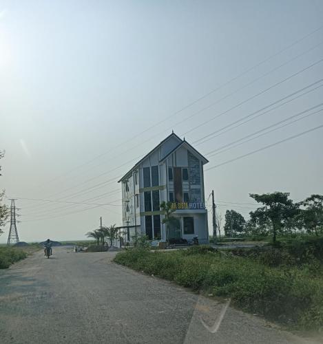 a building on the side of a road with a person on a bike at MR SIETS hotel in Châu Xá