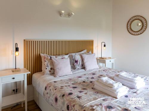a bedroom with a large bed with pillows at Photography House by PontaNegraAzores in Altares