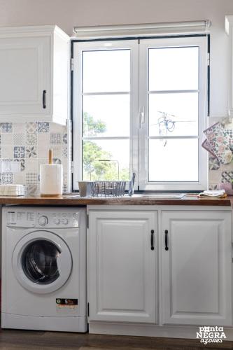 a kitchen with a washing machine and a window at The Biscuit House by PontaNegraAzores in Praia da Vitória