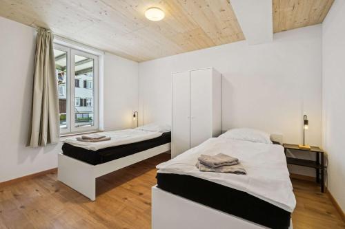 a bedroom with two beds and a window at FENUS SGT01 moderne Ferienwohnung in Grabs