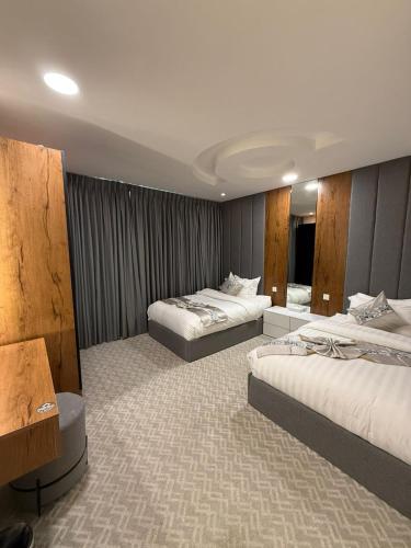 a hotel room with two beds in a room at شقق كورال الفندقية in Buraydah