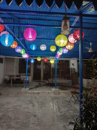 a group of colorful lights hanging from a blue ceiling at Budget stays in New Delhi