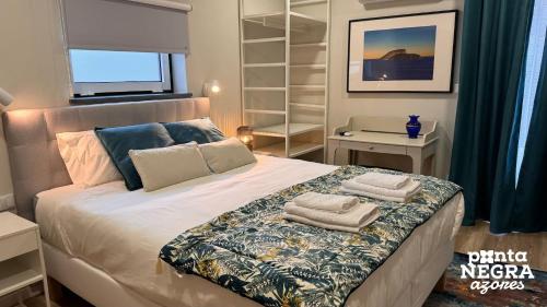 a bedroom with a bed with towels on it at Quinta de São José by PontaNegraAzores in Angra do Heroísmo