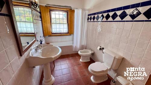 a bathroom with a sink and a toilet at Casa da Hortênsia Roxa by Ponta Negra Azores in Praia da Vitória