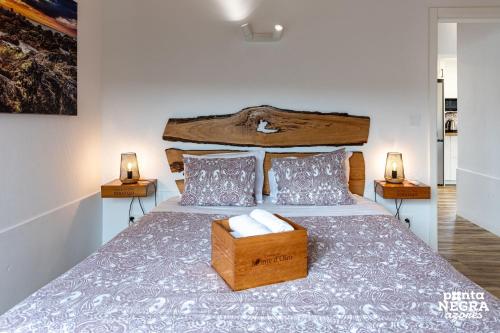 a bedroom with a large bed with a wooden headboard at Wine House by Ponta Negra Azores in Altares