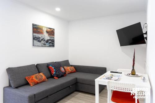 a living room with a couch and a table at City House by PontaNegraAzores in Angra do Heroísmo