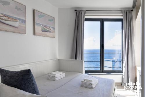 a bedroom with a bed with a view of the ocean at Casa Maré by PontaNegraAzores in Angra do Heroísmo