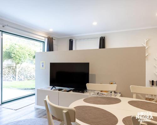 a dining room with a table and a tv at Quinta de São José by PontaNegraAzores in Angra do Heroísmo