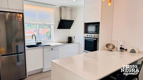 a kitchen with white appliances and a white counter top at City House by PontaNegraAzores in Angra do Heroísmo