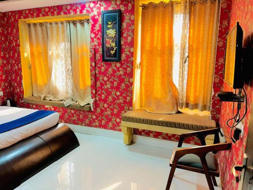 a bedroom with a bed and curtains and a chair at Hostel stay bless in Jaisalmer