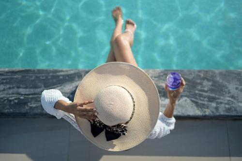 a woman in a straw hat sitting in a pool at Andaman Riviera in Bang Tao Beach
