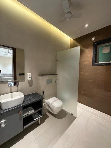 a bathroom with a white toilet and a sink at ANANTYA BANQUET and HOTEL in Sonīpat