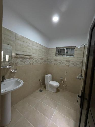a bathroom with a toilet and a sink at Rose Family Lodges in Islamabad
