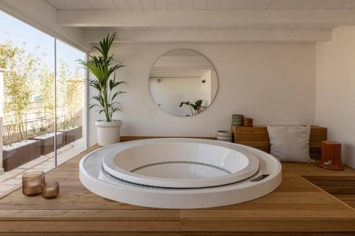 a large white tub in a room with a mirror at Palazzo Cerere Boutique Hotel in Polignano a Mare