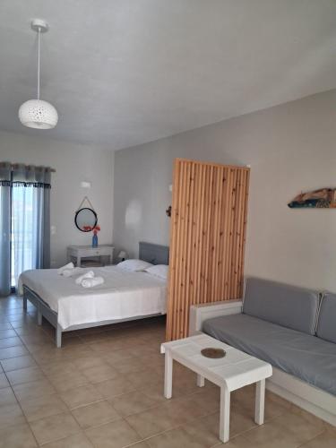 a bedroom with two beds and a couch at Elia Studios in Palekastron