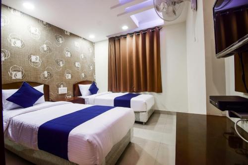 a hotel room with two beds and a flat screen tv at Hotel Grand Eagle Group in Jaipur